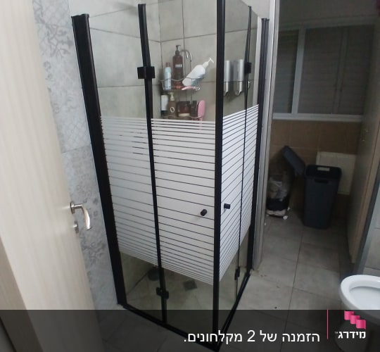 מקלחון פינתי מותקן עם פרופיל שחור בחדר רחצה